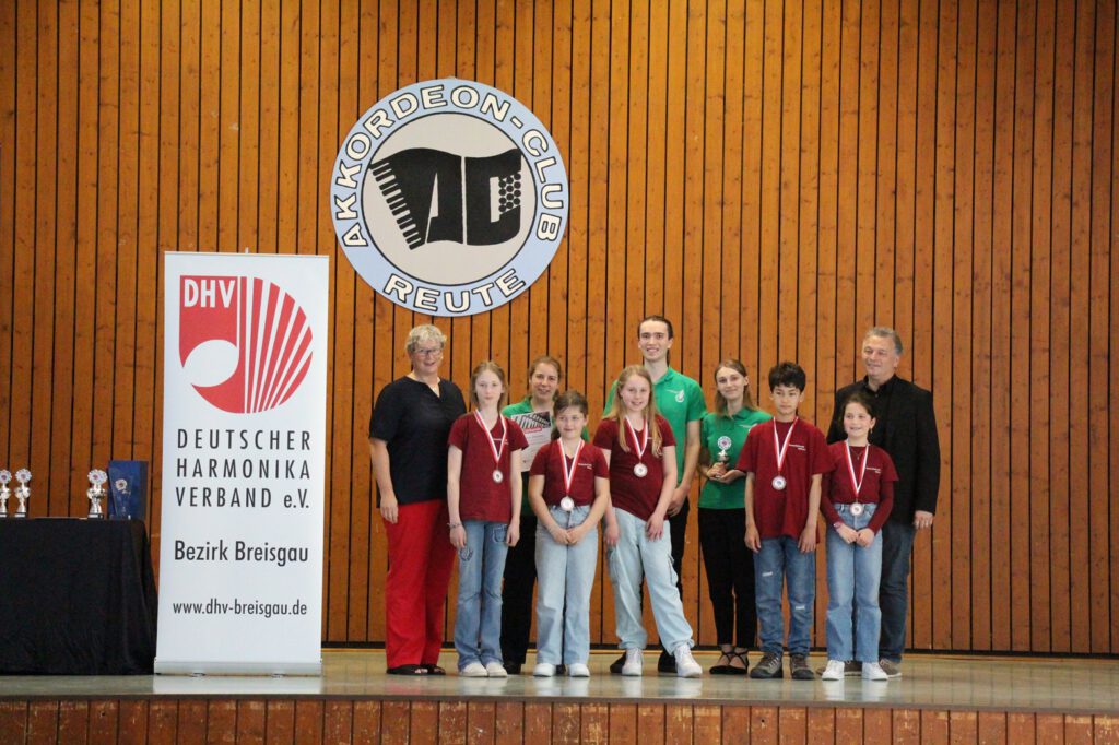 Die erfolgreichen Ensembles: die jüngsten Teilnehmer, das Schüler-Ensemble der Harmonikafreunde Müllheim (vorne), sowie das Ensemble „Allegro giocoso“ des 1. Akkordeonorchesters Emmendingen (hinten), umrahmt von der Bezirksvorsitzenden Andrea Rappenecker (links) und Bezirksdirigent Franco Coali (rechts).
